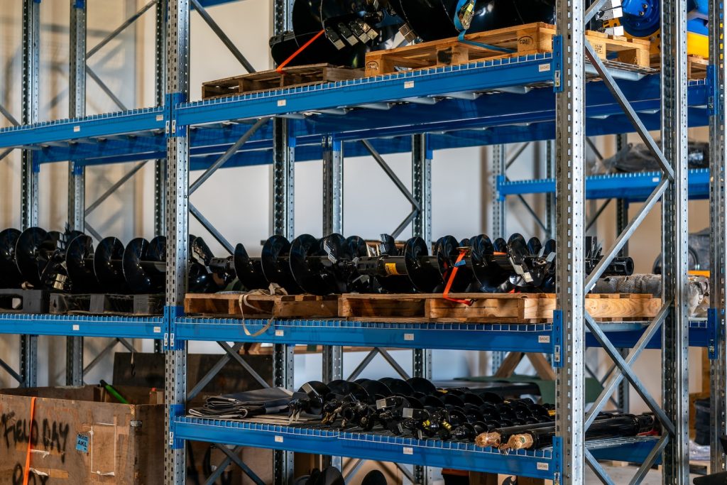 Hydraulic auger attachments organised on shelves at the Earthworm distribution centre in Christchurch.